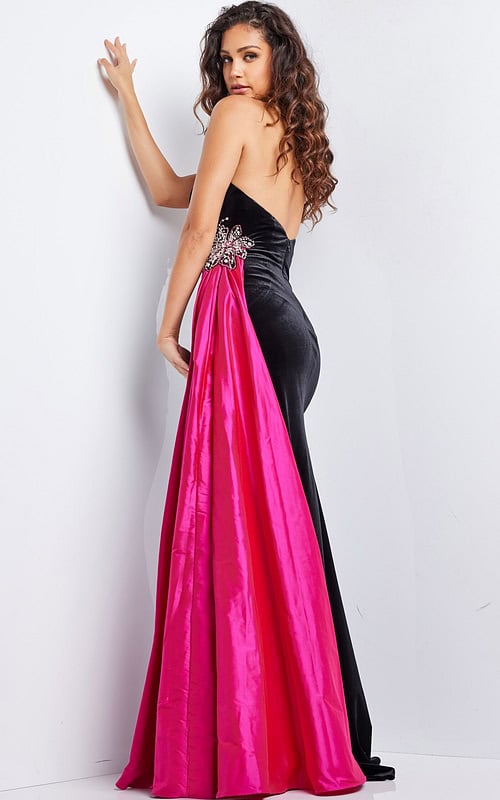 Model wearing Jovani 26117 black gown with fuchsia train, back view showcasing intricate embellishments.
