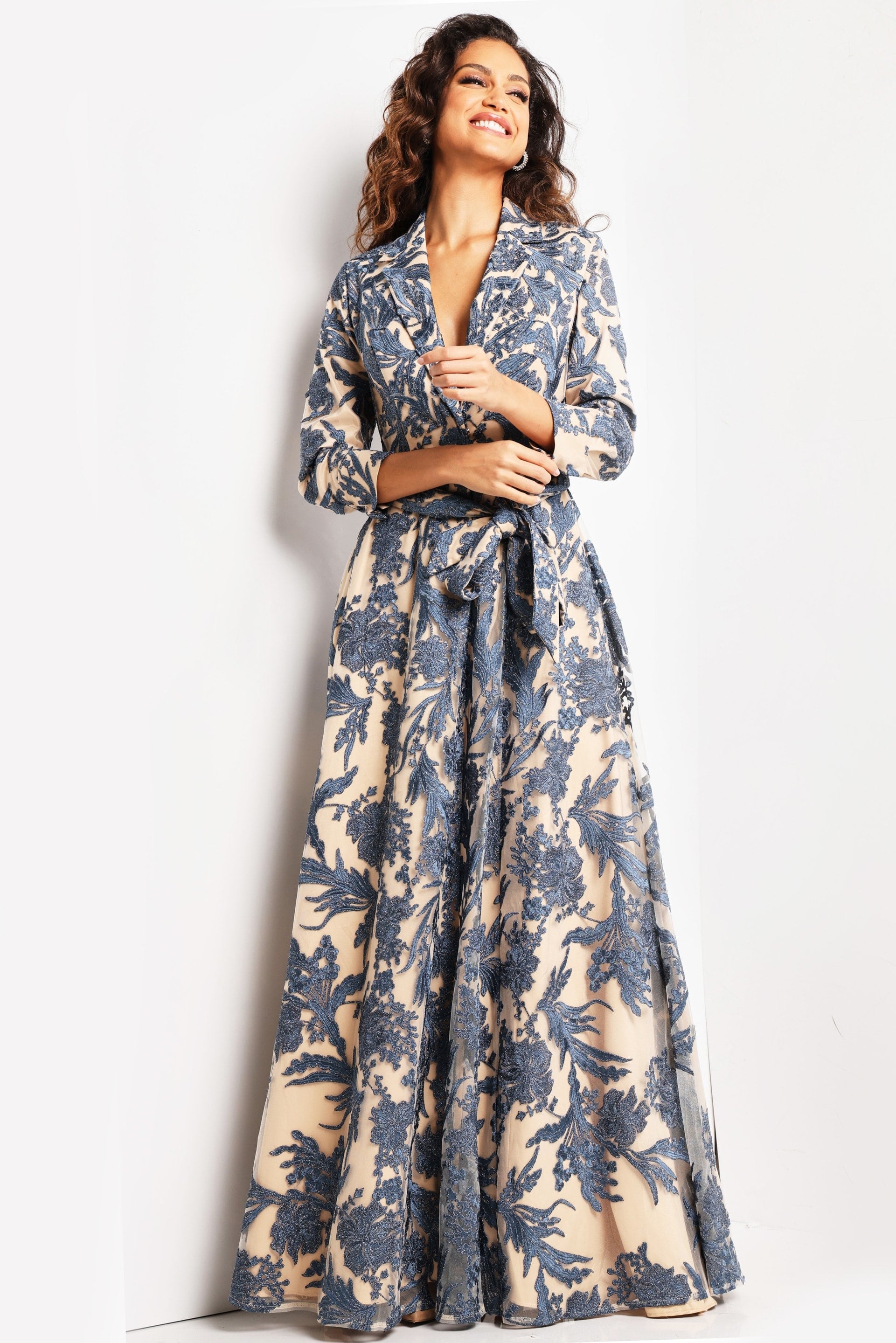 26148_NAVYNUDE_24.jpg Model wearing Jovani 26148 navy and nude gown with V-neckline and floral details.