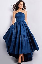 Model wearing Jovani 26152 navy strapless dress with full skirt.