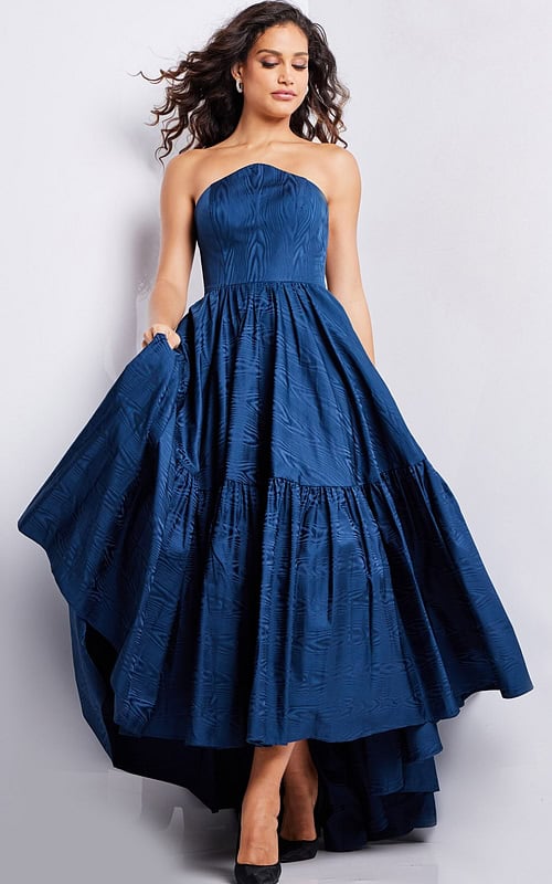 Model wearing Jovani 26152 navy strapless dress with full skirt.