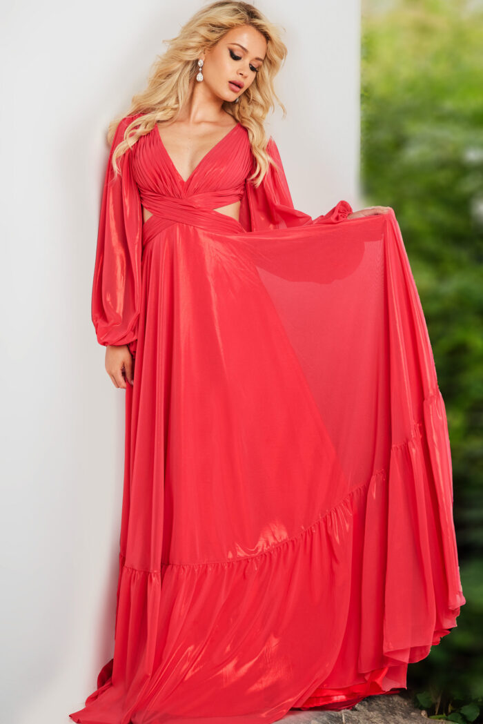Model wearing Jovani 26247 coral floor-length gown with airy long sleeves