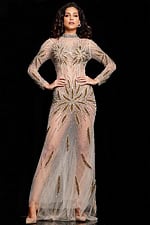 Model wearing Jovani 26257 nude gown with gold embellishments, front view with hands on hips.