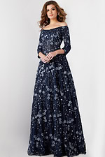 Model in Jovani 26331 navy dress showcasing floral details and off-shoulder neckline.