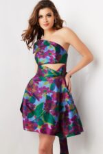 Model wearing Jovani 34408 knee-length floral dress with asymmetrical neckline and cut-out details from the front.