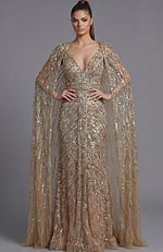 Full length view of a beaded column gown with sheer cape sleeves and defined waist