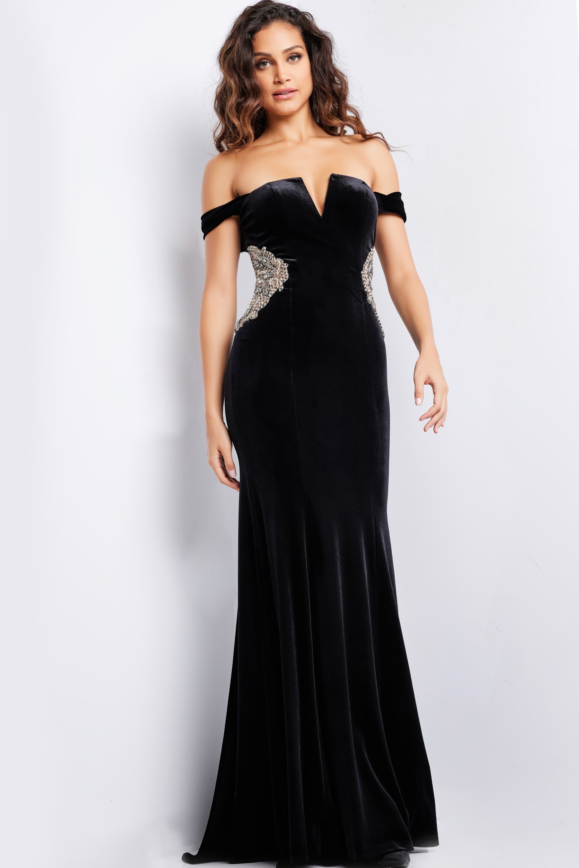 36733_BLACK_4.jpg Model wearing Jovani 36733 black off-the-shoulder gown with side embellishments, front view.