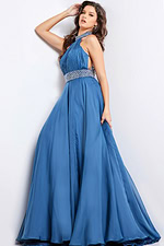 Model in Jovani 36749 navy gown featuring beaded waistband and pleated bodice.