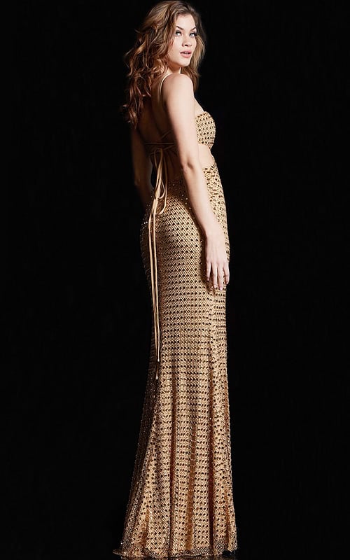 Model showing the back of Jovani 36810, gold gown with open back and lace-up detailing.
