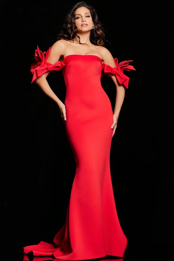 Model showcases Jovani 36997 red off-the-shoulder evening dress with elegant bows on the sleeves.