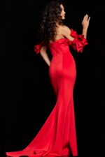 Model from behind in Jovani 36997 red mermaid gown with flared skirt and dramatic sleeve bows.