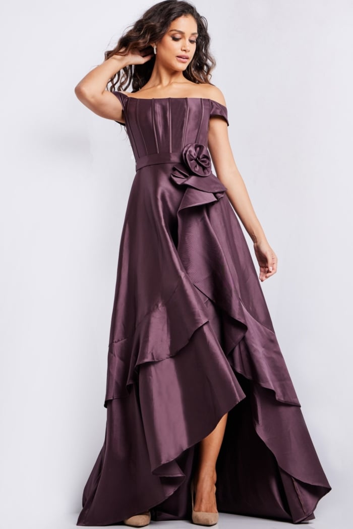 Model in Jovani 37014 brown off-shoulder dress with a cascading layered skirt.