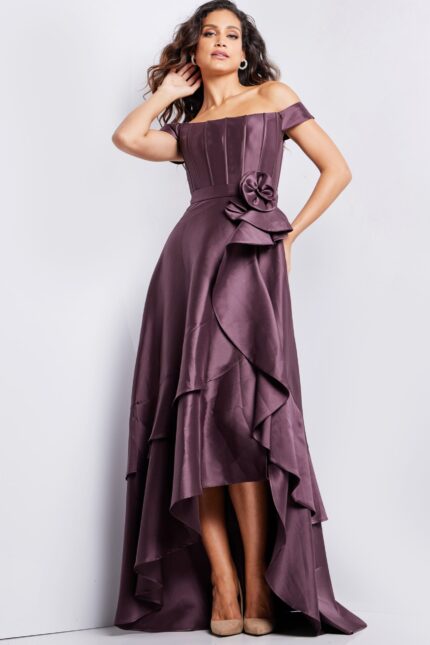 Model wearing Jovani 37014 brown dress with off-shoulder neckline and rosette detail at waist.
