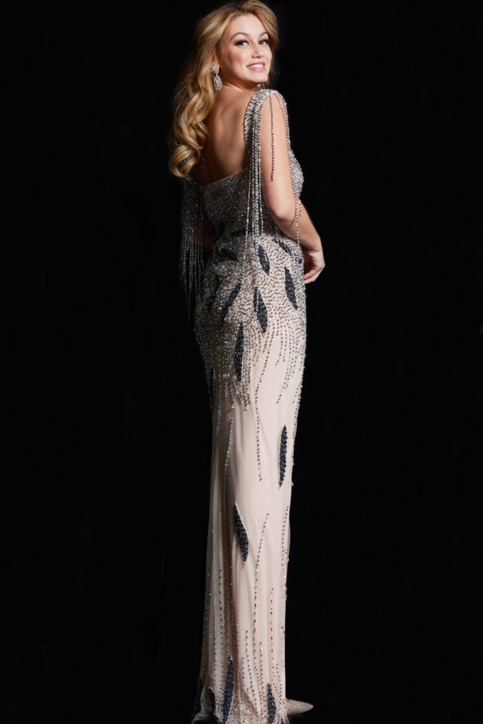 Back view of model in Jovani 37073 nude gown with beadwork and fringe sleeves