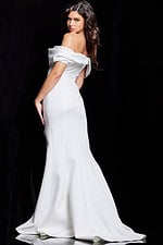 Model showing the back of Jovani 37148 white gown, highlighting off-the-shoulder style and flared bottom.