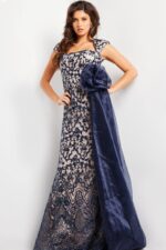 Model showcasing Jovani 37203 navy dress with floral applique and chiffon sash.