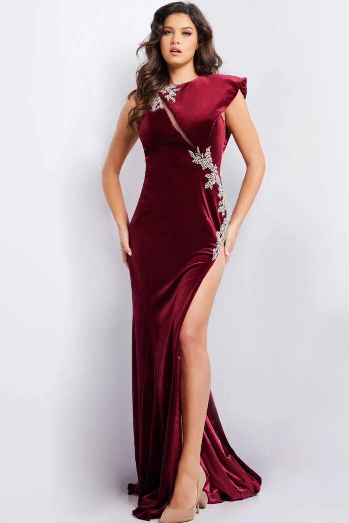 Model wearing Jovani 37341 burgundy velvet dress with asymmetric neckline and high slit