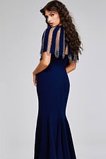 Model displaying the back of Jovani 37386 navy dress with cape sleeves and elegant silhouette.