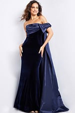 Model wearing Jovani 37391 navy off-the-shoulder gown featuring an asymmetrical bow detail.