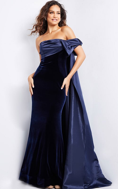 Model wearing Jovani 37391 navy off-the-shoulder gown featuring an asymmetrical bow detail.