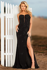 Model posing in Jovani 37624 black gown with a high slit and floral embroidery.