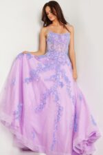 Model showcasing Jovani 37700 lilac ball gown, holding the skirt, front view.