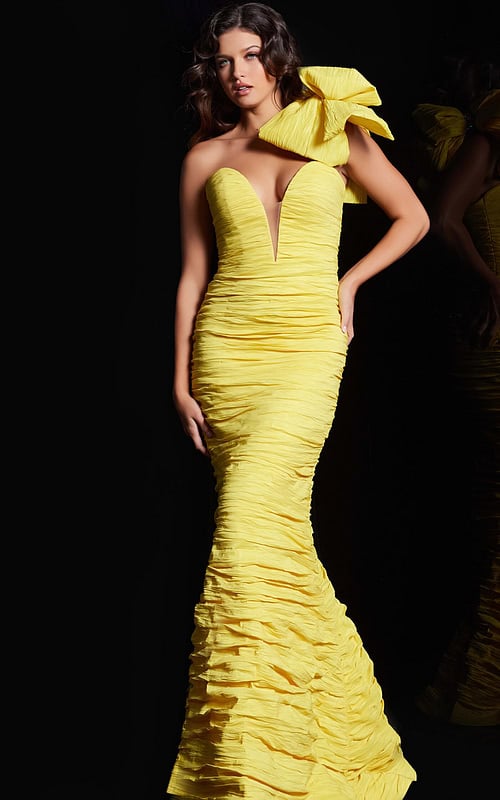 Model wearing Jovani 38240 yellow dress with deep V neckline and bow.