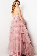 Model wearing Jovani 38577 pink dress with open back and tiered silhouette, back view.