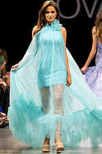 model wearing Jovani 38720 blue dress with high neckline and flowing layers from the front view