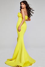 Model wearing Jovani 38922 in yellow, angled back view with flowing hemline.