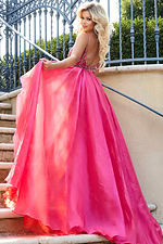 Model revealing back of Jovani 39042 red gown with flowing train.