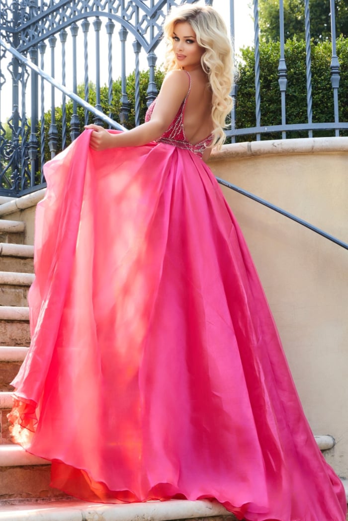 Model revealing back of Jovani 39042 red gown with flowing train.