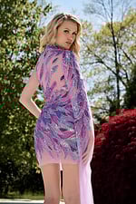 Model wearing Jovani 39062 lilac dress from the back showcasing sequined design and cape.