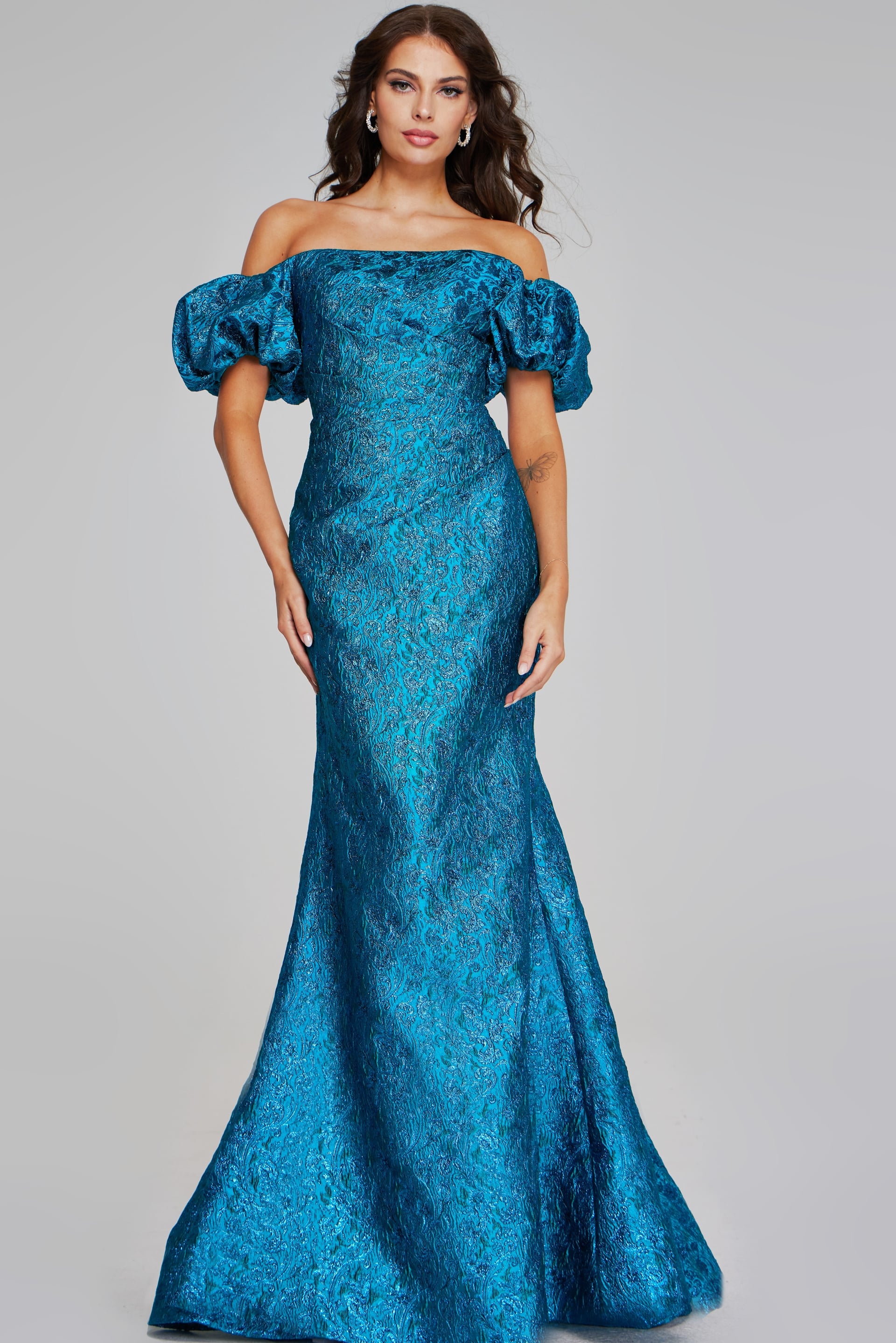 39113-TEAL-201.jpg Model wearing Jovani 39113, an off-the-shoulder teal dress with puffed sleeves and a fitted design.