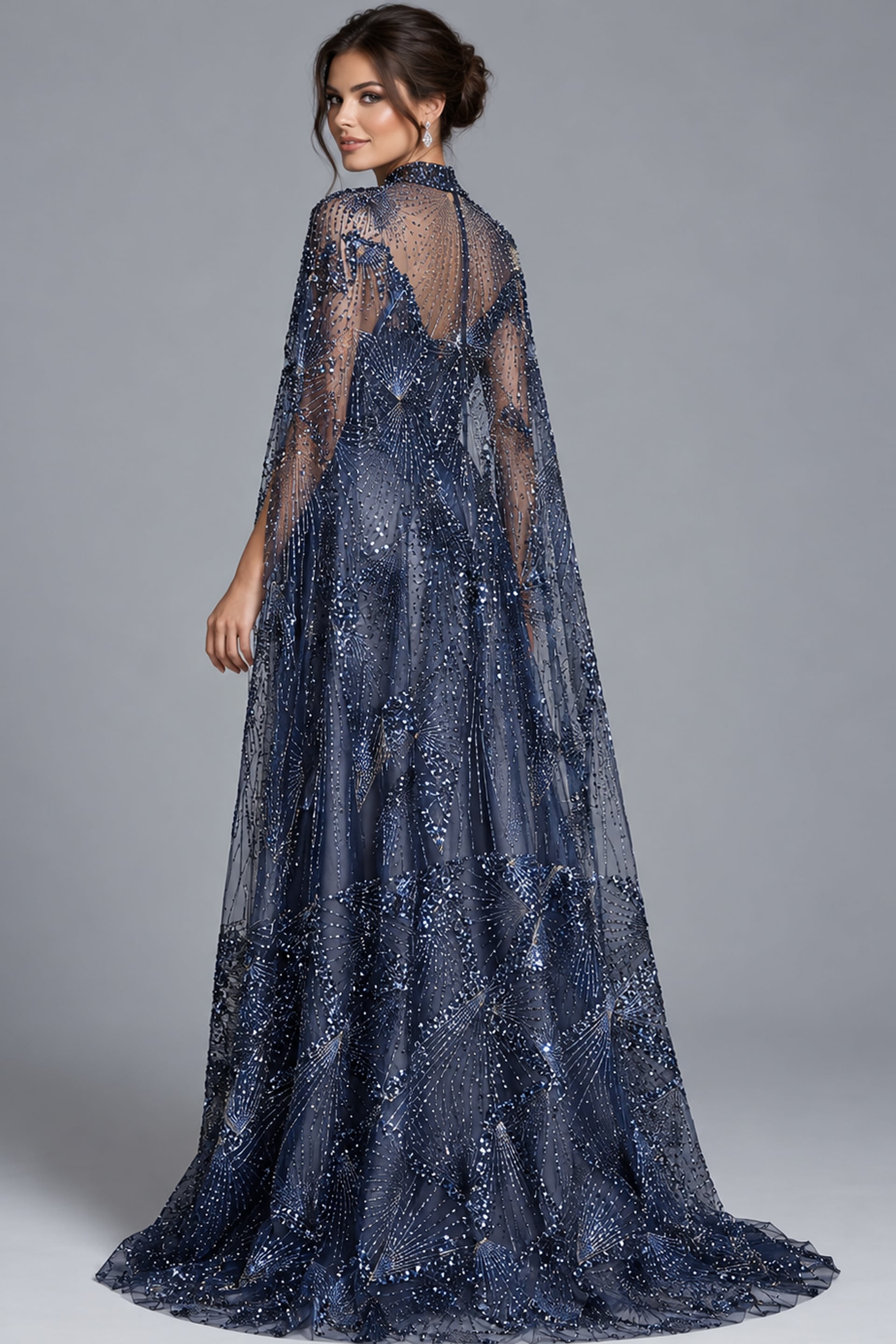 Navy beaded cape gown shown from the back at an angle with sweeping train
