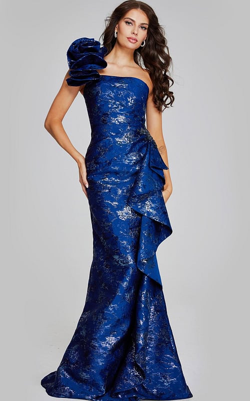 Model wearing Jovani 39438 navy dress with one-shoulder floral detail and mermaid silhouette.