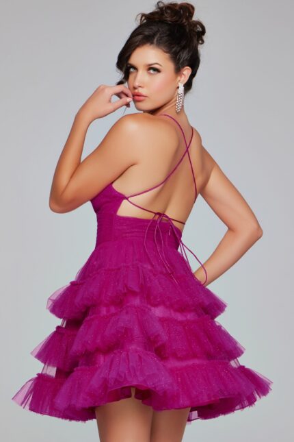 Back view of model in Jovani 39655 with crisscross straps and layered skirt in fuchsia.