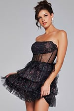 Model wearing Jovani 39666 black dress, front view holding skirt.