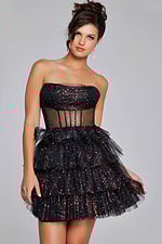 Model wearing Jovani 39666 black dress, front view holding skirt to side.