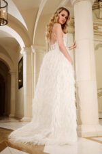 Model showing the back of Jovani 39677 white gown with feather detailing.
