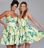 Two models showcasing Jovani 39881 green floral dresses with flared skirts.