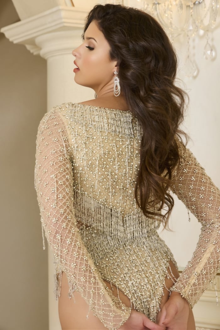 Back view of model wearing Jovani 39955 nude beaded bodysuit with fringe accents.