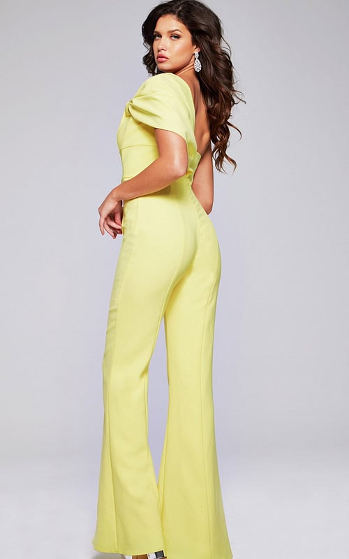 Model wearing Jovani 39961 yellow one-shoulder jumpsuit, back view.