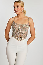 Model wearing silver beaded corset-style top with white fitted pants, front view.