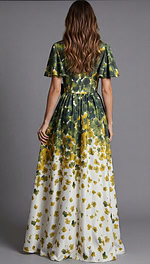 Rear view of a floor length gown with green and yellow floral print and flowing skirt