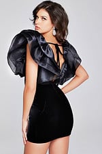 Model showing the back of Jovani 40140 black dress with ruffled sleeve detail and open back tie closure.