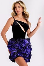 Woman wearing a black velvet one-shoulder dress with purple satin rosettes