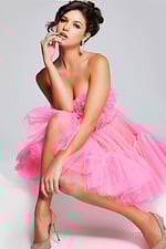 Model sitting wearing Jovani 40186 pink strapless short dress.