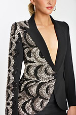 Close-up of beaded swirl pattern on blazer and structured deep V neckline.