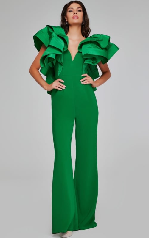 Model wearing Jovani 40291 emerald green jumpsuit featuring a V-neckline and dramatic ruffled sleeves.