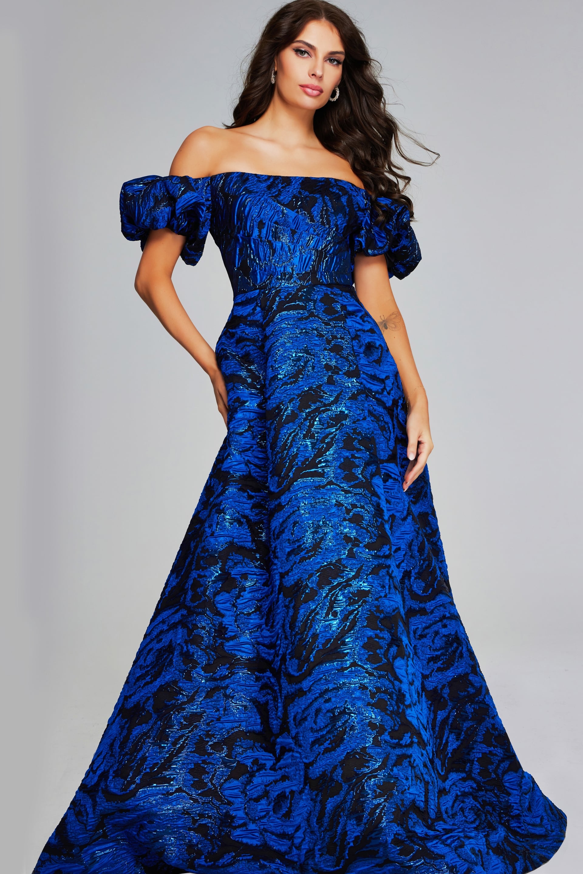 40315-ROYALBLACK-202.jpg Model wearing Jovani 40315, a royal blue off-the-shoulder gown with puff sleeves.